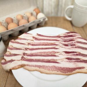 strips of uncooked bacon on plate
